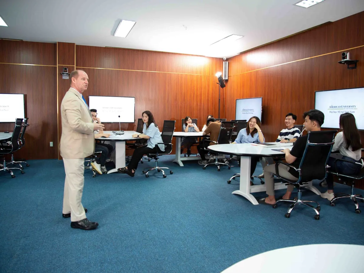 A professor leads a discussion in a screen-equipped AUV classroom