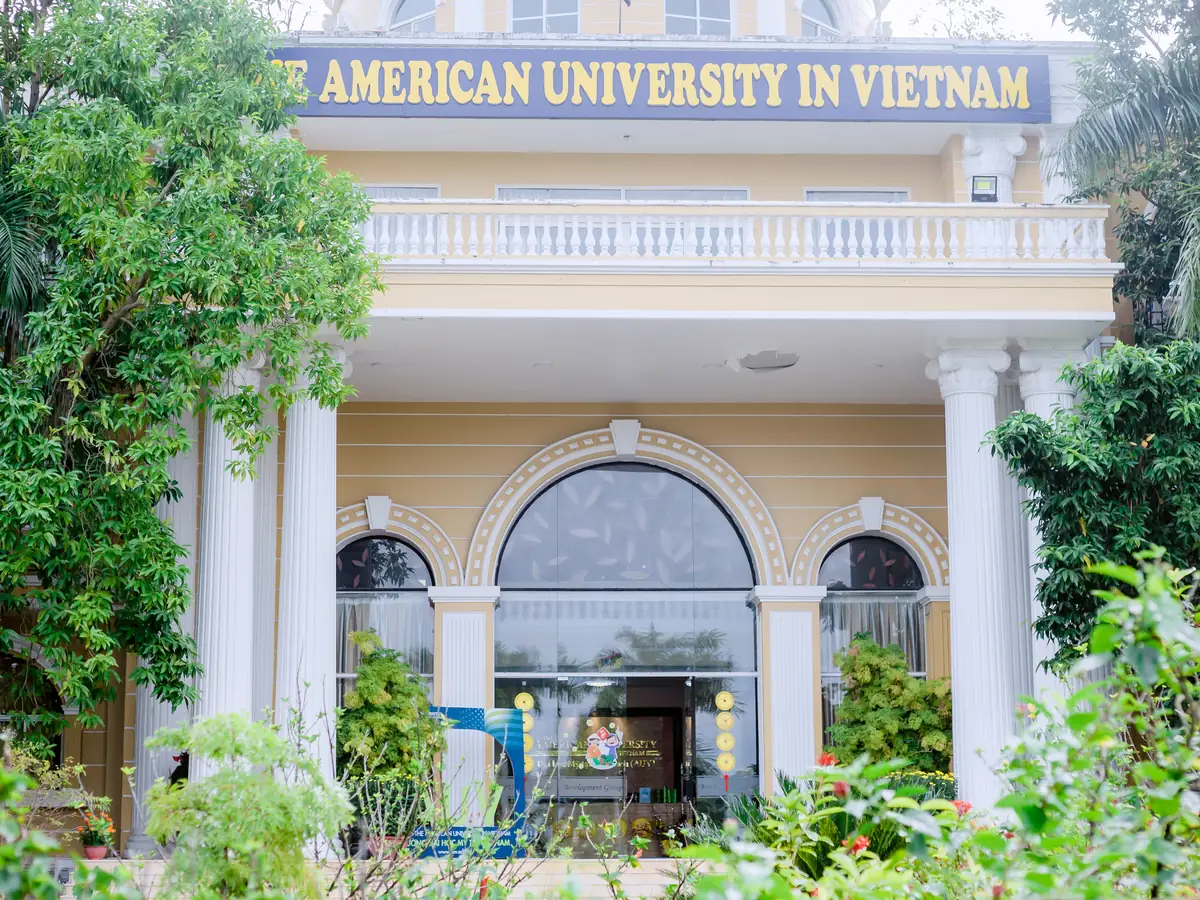 The entrance of the AUV main building framed by gardens and palms