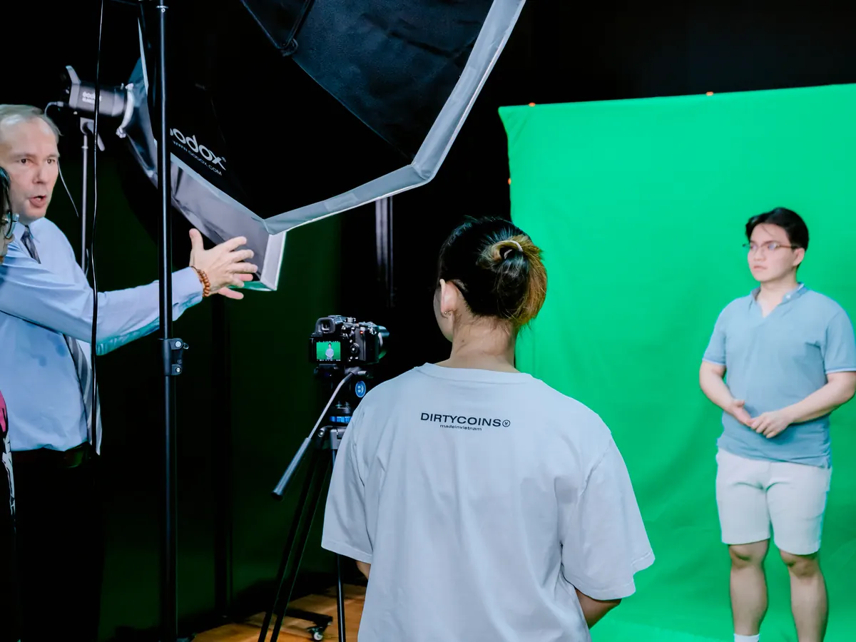 A professor shows students how to light a green-screen shoot