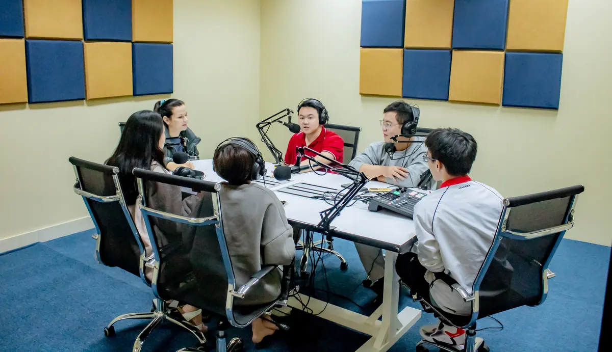Students and a faculty member around the podcast table